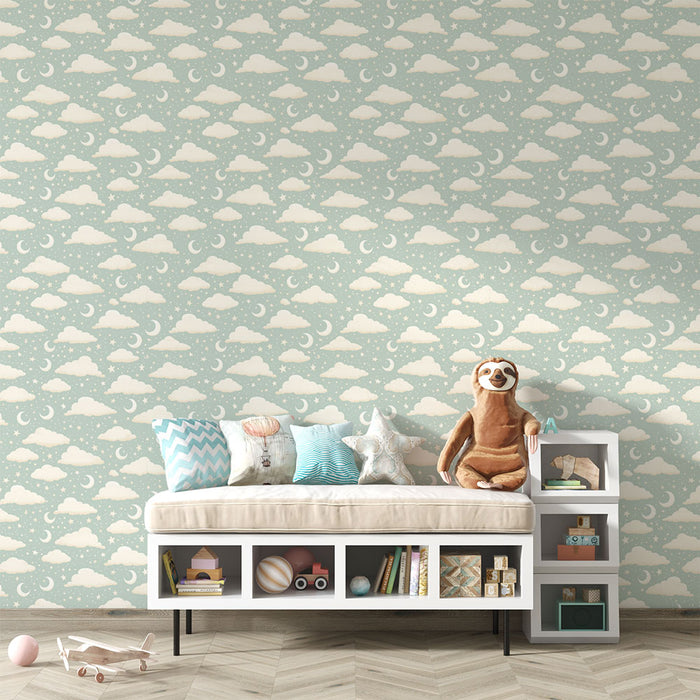 Une chambre d'enfant avec un papier peint illustrant des nuages et des croissants de lune sur fond bleu clair, créant une atmosphère douce et rêveuse.