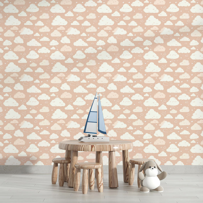 Une chambre d'enfant avec un papier peint pastel représentant des nuages blancs sur fond rose, créant une atmosphère douce et rêveuse.