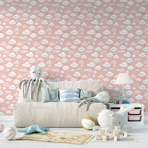 Une chambre enfantine avec un papier peint rose orné de nuages souriants en blanc, créant une ambiance douce et ludique.