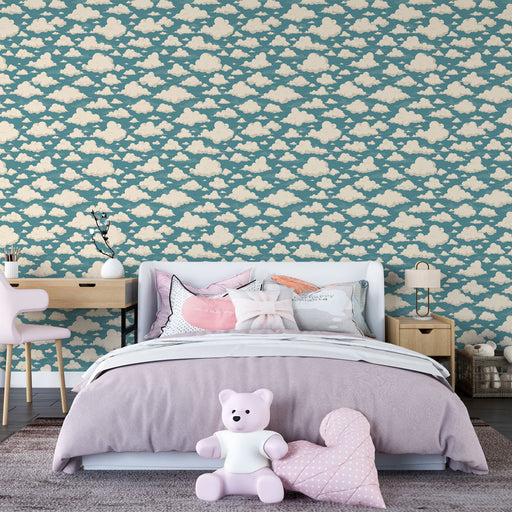 Une chambre enfantine avec un papier peint bleu canard orné de nuages crème, créant une atmosphère douce et rêveuse.