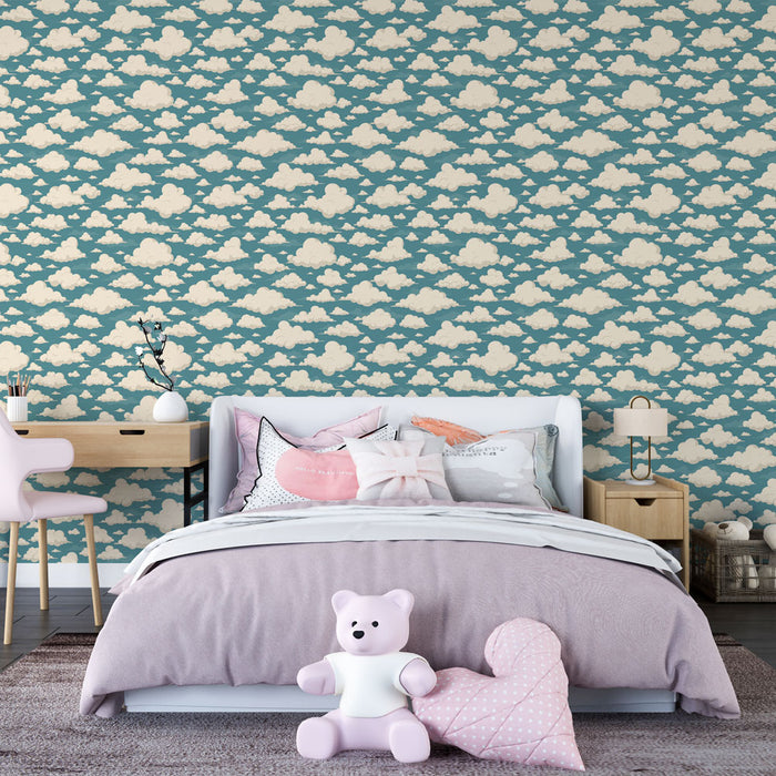 Une chambre enfantine avec un papier peint bleu canard orné de nuages crème, créant une atmosphère douce et rêveuse.