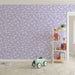 Une chambre d'enfant avec un papier peint pastel violet orné de nuages blancs, créant une atmosphère douce et rêveuse.