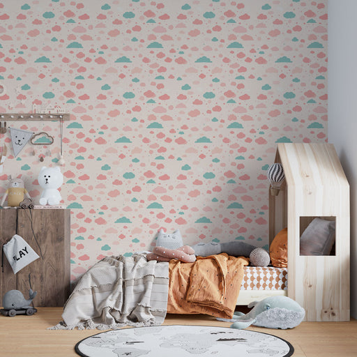 Une chambre d'enfant avec un papier peint aux motifs de nuages roses et bleus sur fond clair, créant une ambiance douce et ludique.
