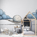 Une chambre d'enfant avec un papier peint illustratif représentant un nuage et une lune endormie, créant une atmosphère douce et rêveuse.