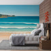 Une chambre apaisante avec un papier peint représentant une plage ensoleillée, aux vagues turquoise et sable doré, créant une atmosphère relaxante et estivale.