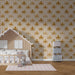 Une chambre d’enfant avec un papier peint aux motifs d'octopodes dorés sur fond crème, créant une ambiance ludique et chaleureuse.