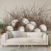Un salon contemporain avec un papier peint illustrant des œufs enroulés dans de l'herbe, dégageant une ambiance naturelle et artistique en nuances de beige et marron.