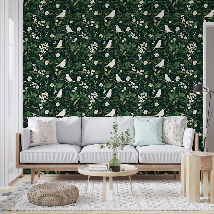 Un salon lumineux avec un papier peint floral vert foncé orné de feuilles luxuriantes et d'oiseaux blancs, créant une atmosphère naturelle et apaisante.