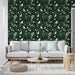 Un salon lumineux avec un papier peint floral vert foncé orné de feuilles luxuriantes et d'oiseaux blancs, créant une atmosphère naturelle et apaisante.
