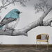 Une pièce moderne avec un papier peint illustrant un oiseau bleu stylisé sur une branche, créant une atmosphère artistique et apaisante.