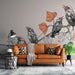 Un salon moderne avec un papier peint illustratif représentant des oiseaux stylisés en noir et orange, créant une ambiance vivante et artistique.