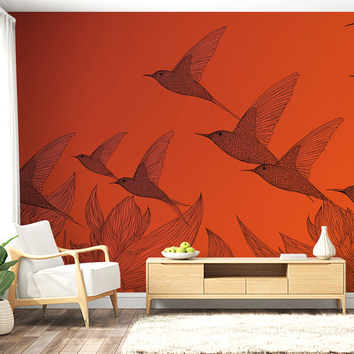Une pièce lumineuse avec un papier peint orange représentant des oiseaux stylisés en vol, créant une atmosphère dynamique et chaleureuse.