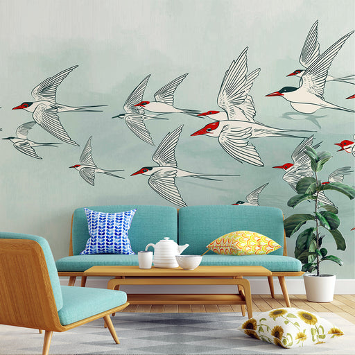 Un salon moderne avec un papier peint illustrant des oiseaux stylisés aux teintes blanches et rouges sur un fond doux, créant une ambiance aérienne et dynamique.