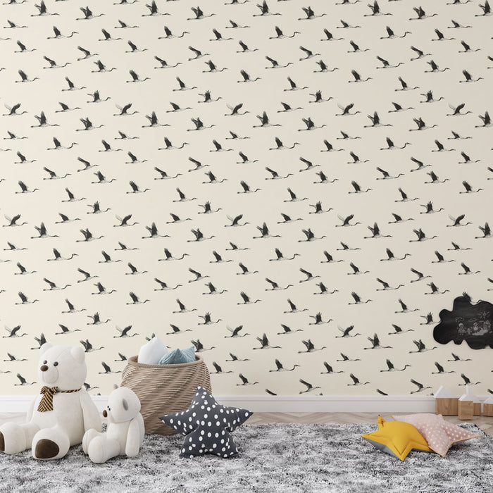 Une chambre enfantine avec un papier peint beige illustrant des oiseaux en vol en noir, créant une atmosphère douce et poétique.