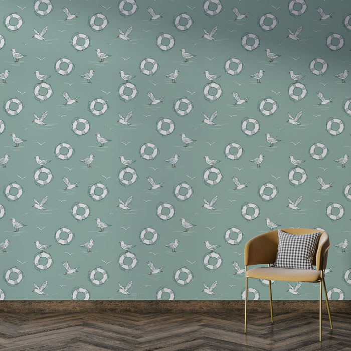 Une pièce moderne avec un papier peint bleu pastel orné de motifs de bouées et d'oiseaux, créant une ambiance marine et estivale.