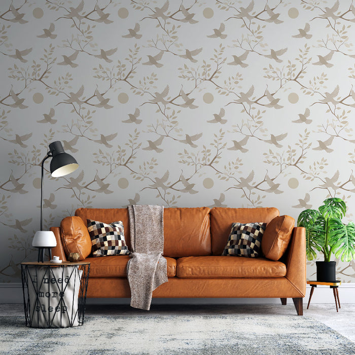 Un salon moderne avec un papier peint aux motifs de branches et d'oiseaux dans des teintes douces de beige sur fond clair, créant une ambiance apaisante et naturelle.