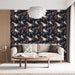 Un salon moderne avec un papier peint floral bleu nuit illustrant des oiseaux et des branches, créant une ambiance chaleureuse et accueillante.
