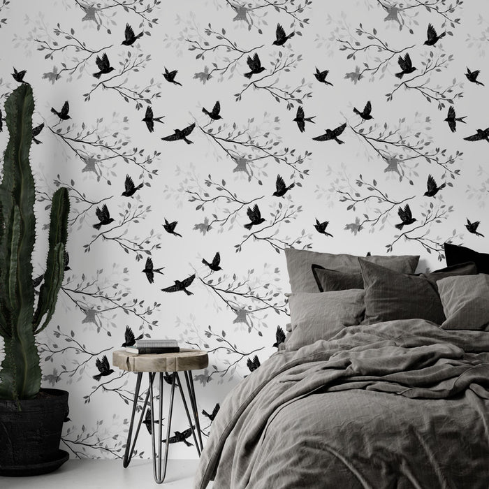 Une chambre moderne avec un papier peint noir et blanc représentant des oiseaux en vol et des branches délicates, créant une ambiance élégante et apaisante.