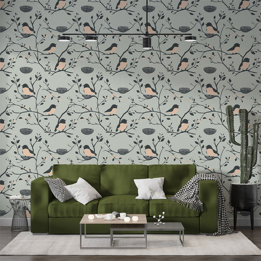 Un salon moderne avec un papier peint floral représentant des oiseaux et des branches sur fond bleu clair, créant une atmosphère douce et accueillante.