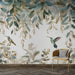 Une salle de séjour avec un papier peint floral représentant des feuilles délicates et des colibris aux teintes douces, créant une atmosphère apaisante et naturelle.