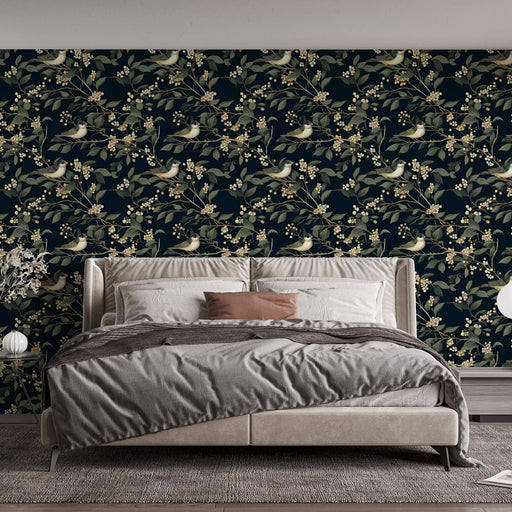 Une chambre élégante avec un papier peint floral bleu nuit orné de délicates branches et oiseaux, créant une atmosphère apaisante et naturelle.