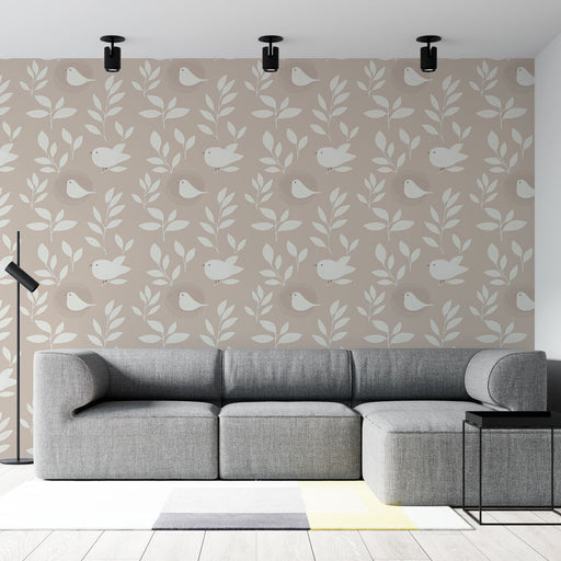 Un salon moderne avec un papier peint beige orné de motifs de feuilles et d'oiseaux stylisés, créant une atmosphère douce et accueillante.