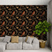 Un salon moderne avec un papier peint noir orné de motifs de oiseaux roux et de branches dorées, créant une ambiance chaleureuse et naturelle.