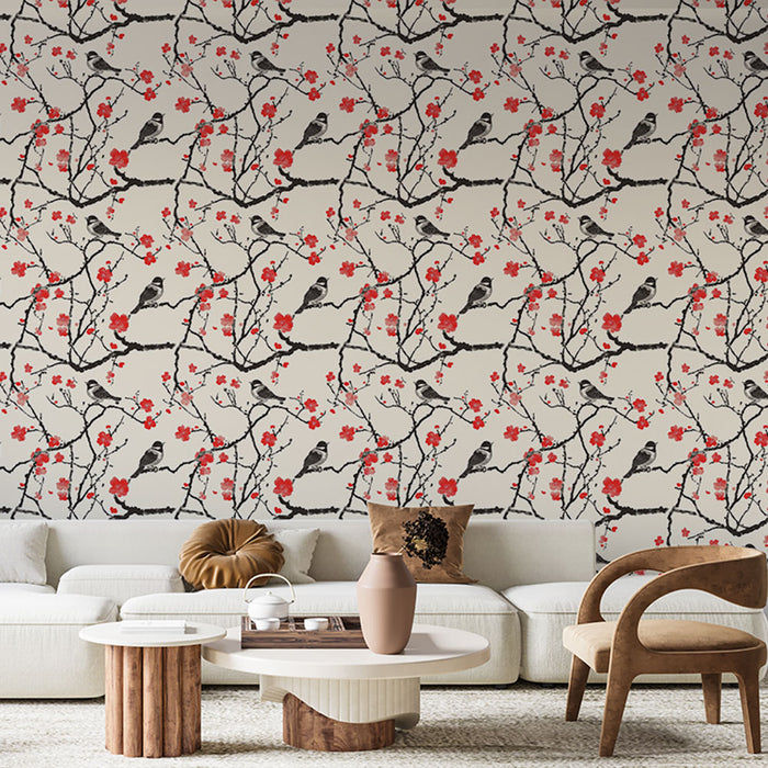 Un salon moderne avec un papier peint floral illustrant des oiseaux perchés sur des branches de cerisier, agrémenté de fleurs rouges sur fond clair.
