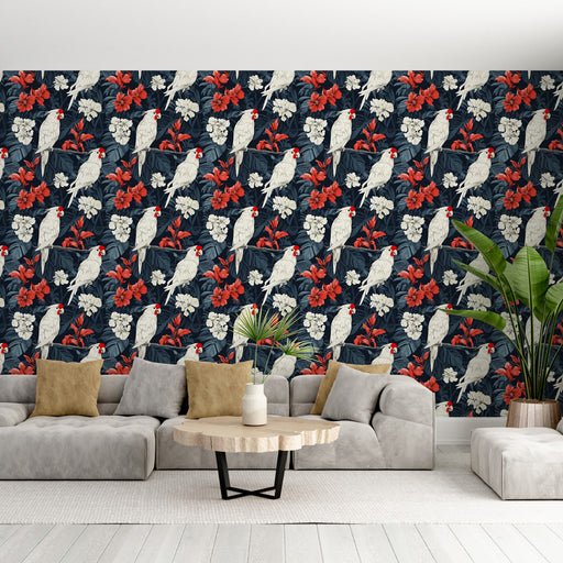Un salon moderne avec un papier peint tropical bleu marine orné de perroquets blancs et de fleurs rouges, créant une ambiance vivante et exotique.