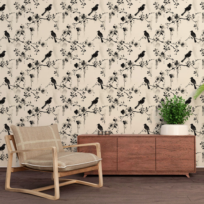 Une salle de séjour avec un papier peint délicat représentant des oiseaux noirs sur des branches fleuries, créant une atmosphère élégante et apaisante.