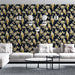 Un salon moderne avec un papier peint floral bleu nuit illustrant des oiseaux dorés perchés sur des branches fleuries, créant une atmosphère élégante et chaleureuse.