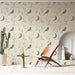 Une pièce lumineuse avec un papier peint aux motifs d'oiseaux et de lunes dans des teintes douces, créant une atmosphère apaisante et naturelle.