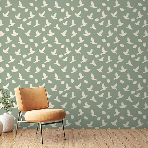 Une pièce moderne avec un papier peint vert doux orné de silhouettes blanches d'oiseaux et de formes ovales, créant une ambiance légère et apaisante.