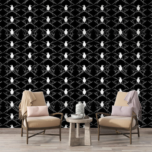 Un salon contemporain avec un papier peint noir orné de motifs blancs représentant des oiseaux stylisés, créant une ambiance moderne et graphique.