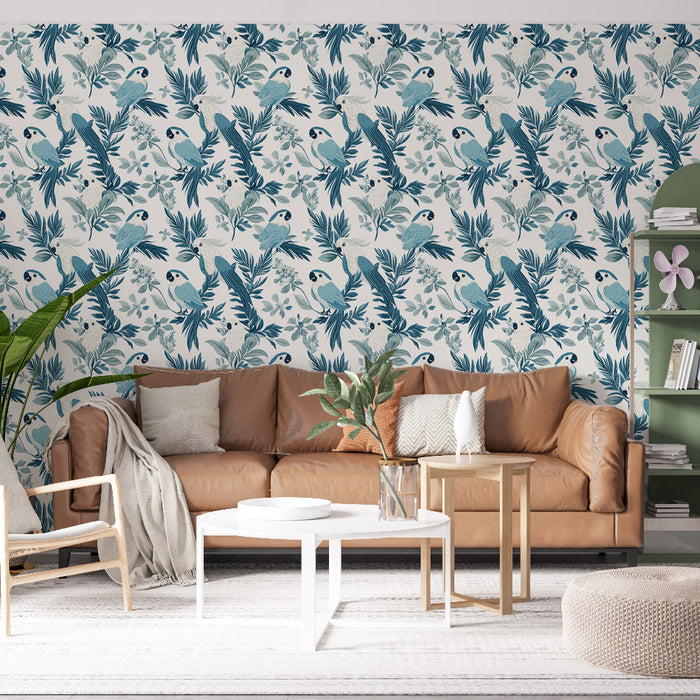 Un salon lumineux avec un papier peint tropical représentant des perroquets et des feuillages dans des teintes de bleu sur fond clair, créant une ambiance vivante et apaisante.