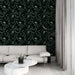 Un salon moderne avec un papier peint tropical noir orné de feuilles luxuriantes et de motifs d'oiseaux, créant une ambiance à la fois élégante et apaisante.