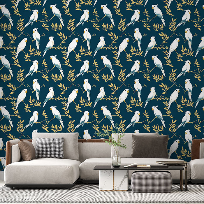 Un salon contemporain avec un papier peint bleu nuit orné de motifs de perruches blanches et de feuillages dorés, créant une ambiance vivante et chaleureuse.