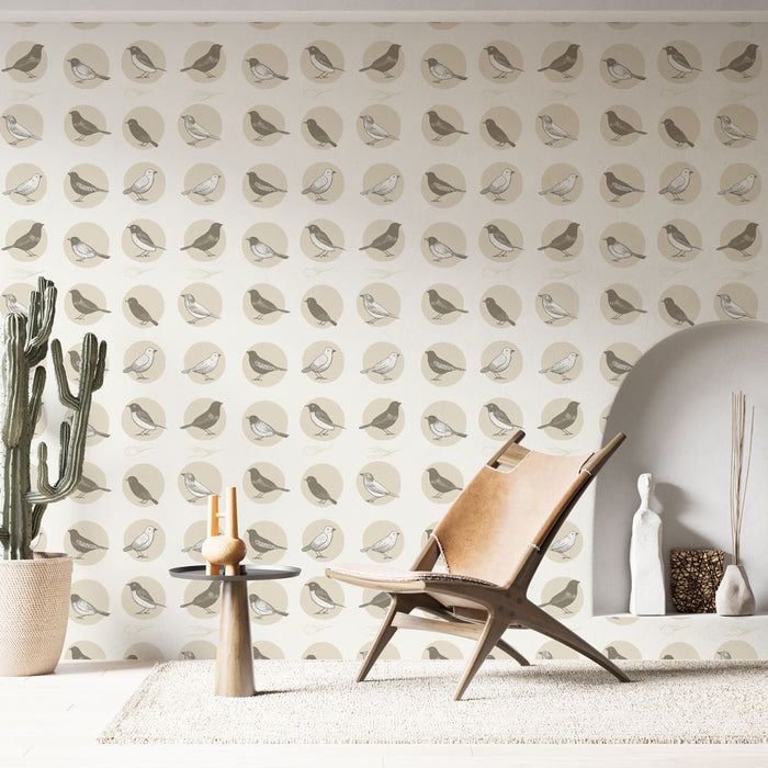 Une pièce lumineuse avec un papier peint illustrant des oiseaux stylisés dans des cercles beige et taupe, créant une atmosphère douce et naturelle.