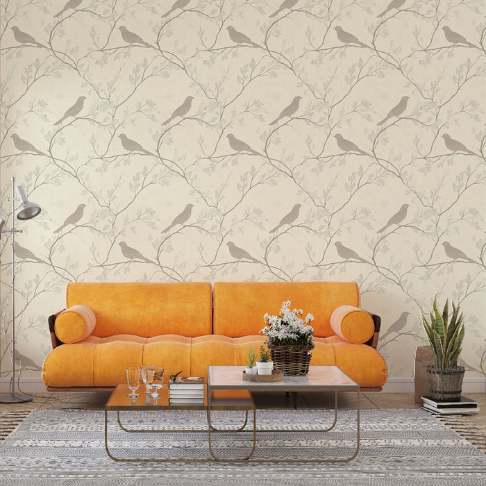 Un salon lumineux avec un papier peint aux motifs de branches délicates et d'oiseaux gris sur fond crème, créant une atmosphère apaisante et naturelle.