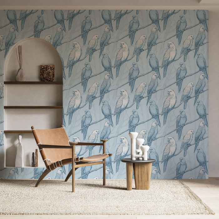 Une pièce lumineuse avec un papier peint illustrant des perroquets en bleu pastel sur fond clair, créant une ambiance fraîche et naturelle.