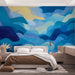 Une chambre moderne avec un papier peint aux vagues fluides dans des nuances de bleu et de jaune, créant une atmosphère apaisante et dynamique.