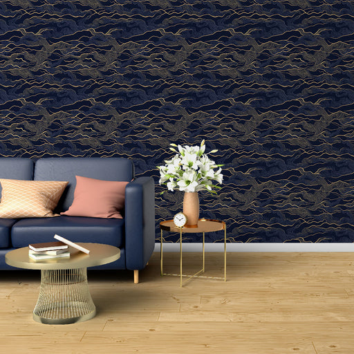 Un salon élégant avec un papier peint bleu marine orné de motifs ondulés dorés, créant une atmosphère sophistiquée et apaisante.