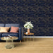 Un salon élégant avec un papier peint bleu marine orné de motifs ondulés dorés, créant une atmosphère sophistiquée et apaisante.