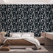 Une chambre moderne avec un papier peint abstrait noir orné de motifs ondulés et de cercles blancs, créant une ambiance dynamique et élégante.