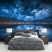 Une chambre moderne avec un papier peint représentant un paysage orageux en bleu profond, créant une ambiance dramatique et captivante.