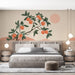 Une chambre moderne avec un papier peint illustrant une branche d'orange sur fond beige, dégageant une atmosphère chaleureuse et estivale.