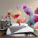 Une chambre accueillante avec un papier peint floral représentant de grandes orchidées aux teintes vives, créant une ambiance fraîche et élégante.
