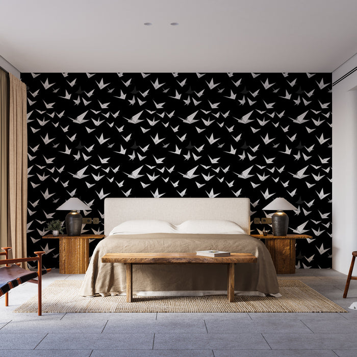 Une chambre moderne avec un papier peint noir orné de motifs de grues blanches en plein vol, créant une atmosphère à la fois élégante et apaisante.