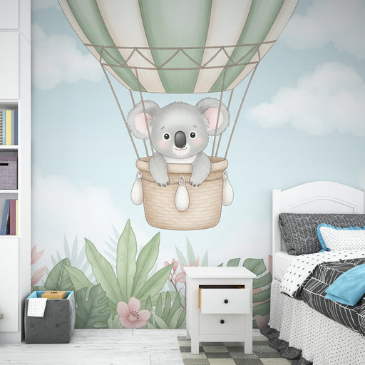 Une chambre enfantine avec un papier peint illustrant un koala dans un ballon montgolfière sur fond pastel, créant une ambiance douce et ludique.