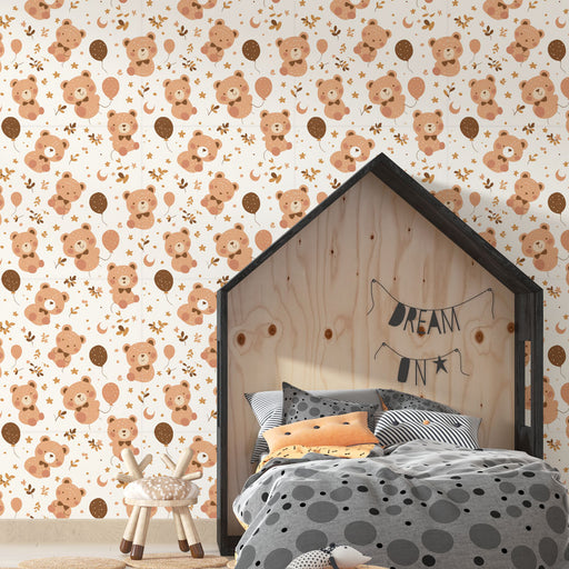 Une chambre d'enfant avec un papier peint ludique représentant des ours en peluche, des ballons et des motifs floraux dans des teintes douces de beige et brun.